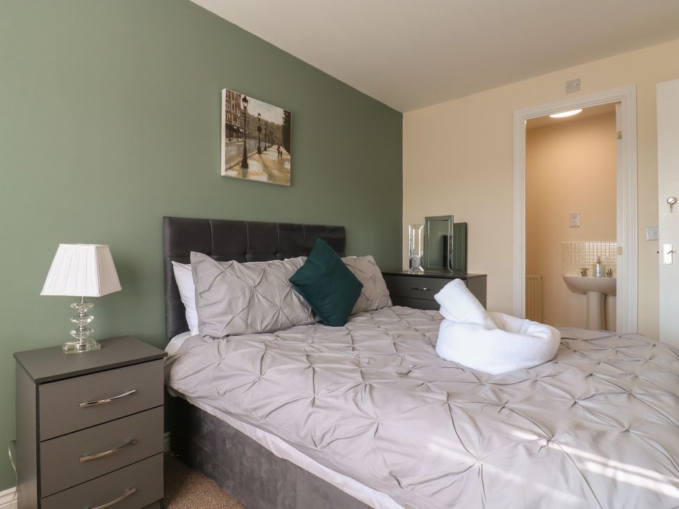 A bedroom with a bed and a bathroom doorway at Gem Relax