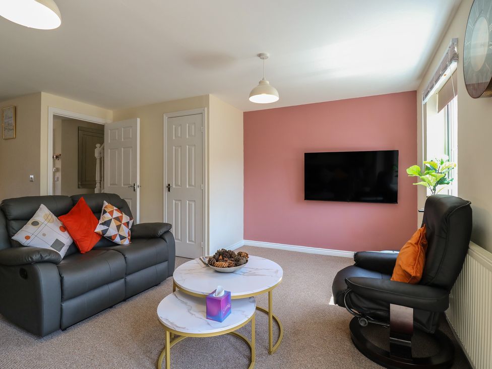 A living room with a sofa and armchair at Gem Relax in Leighton Buzzard