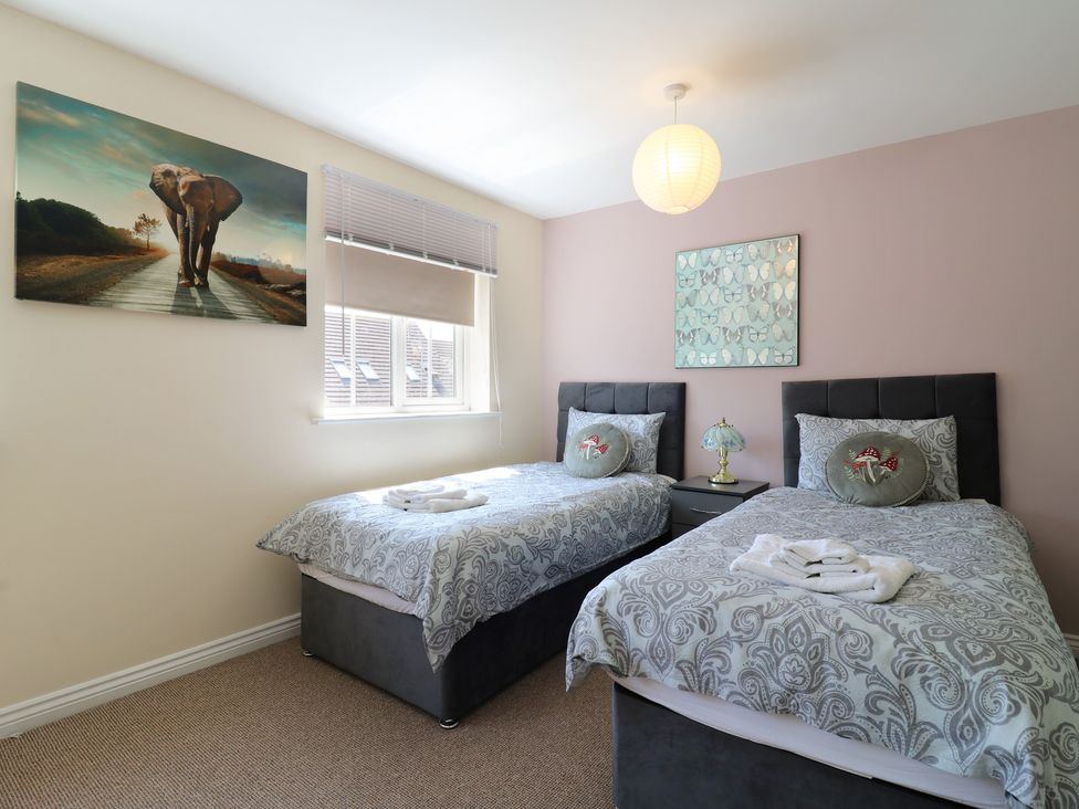 A bedroom with two beds and artwork at Gem Relax in Leighton Buzzard