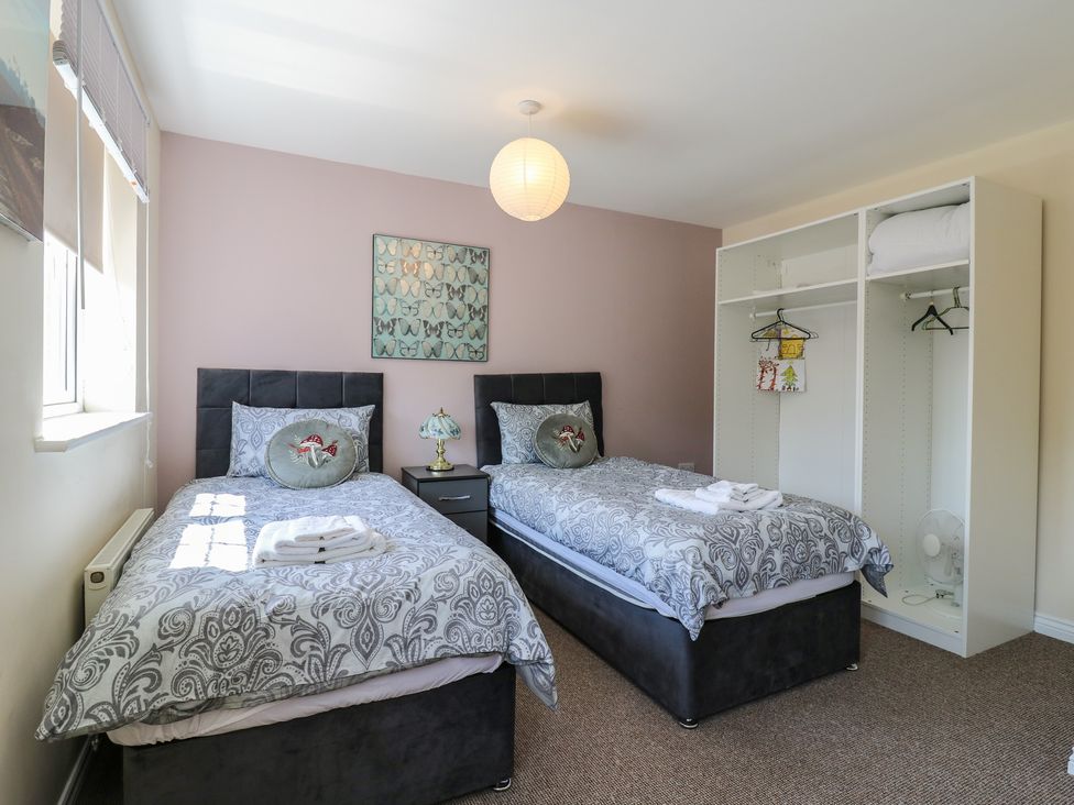 A bedroom with twin beds and wardrobe at Gem Relax in Leighton Buzzard