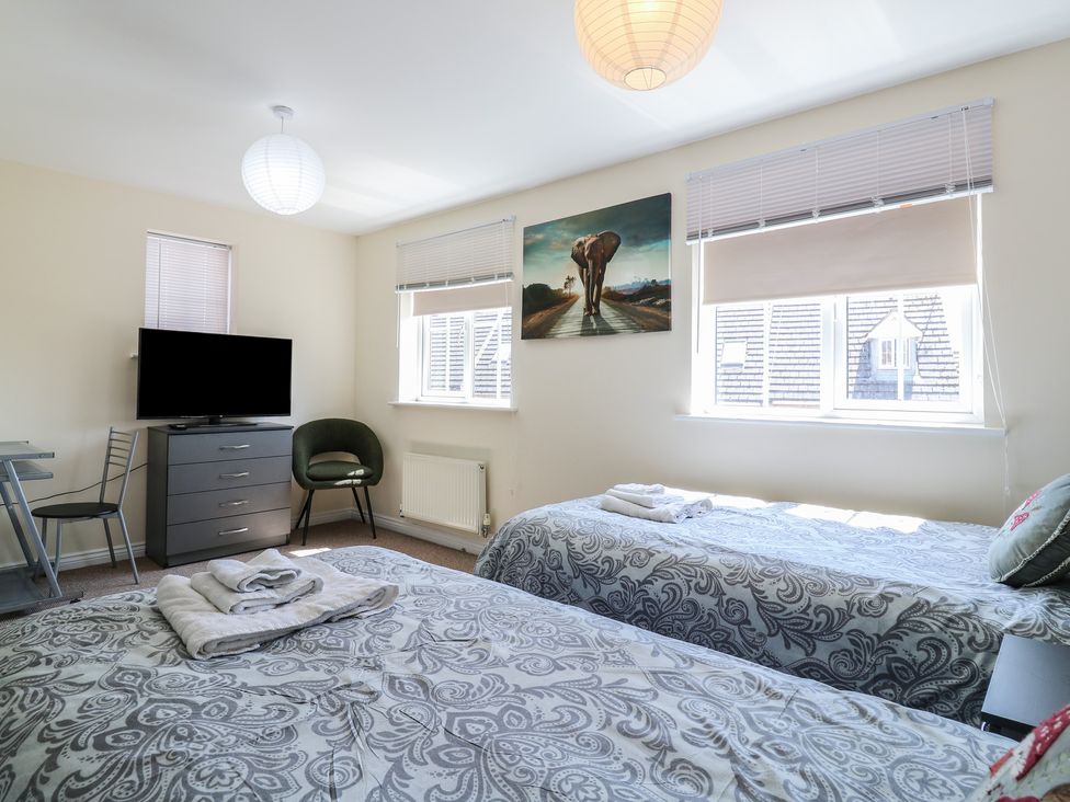 A bedroom with two beds and a television at Gem Relax in Leighton Buzzard