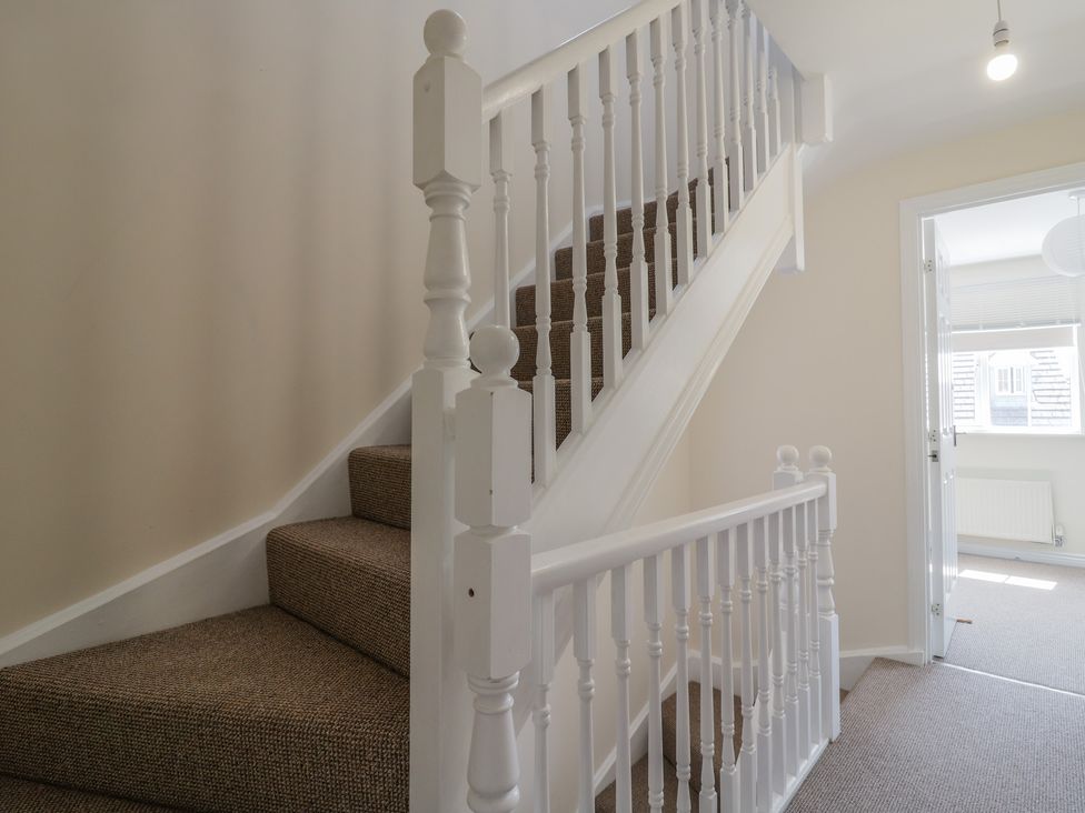 A staircase with carpet and a door at Gem Relax in Leighton Buzzard