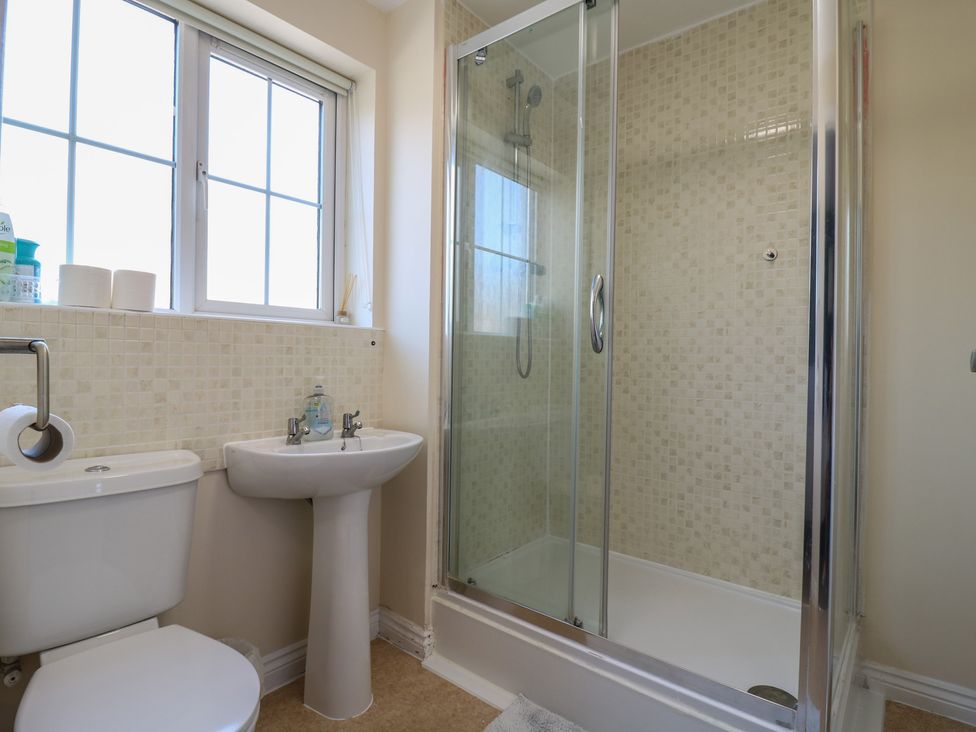 A bathroom with a toilet, sink, and shower at Gem Relax in Leighton Buzzard