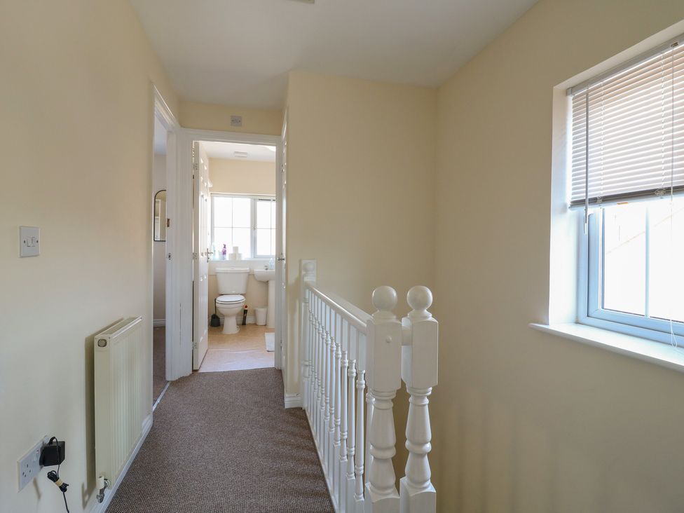 A hallway with a staircase leading to a bathroom at Gem Relax Leighton Buzzard