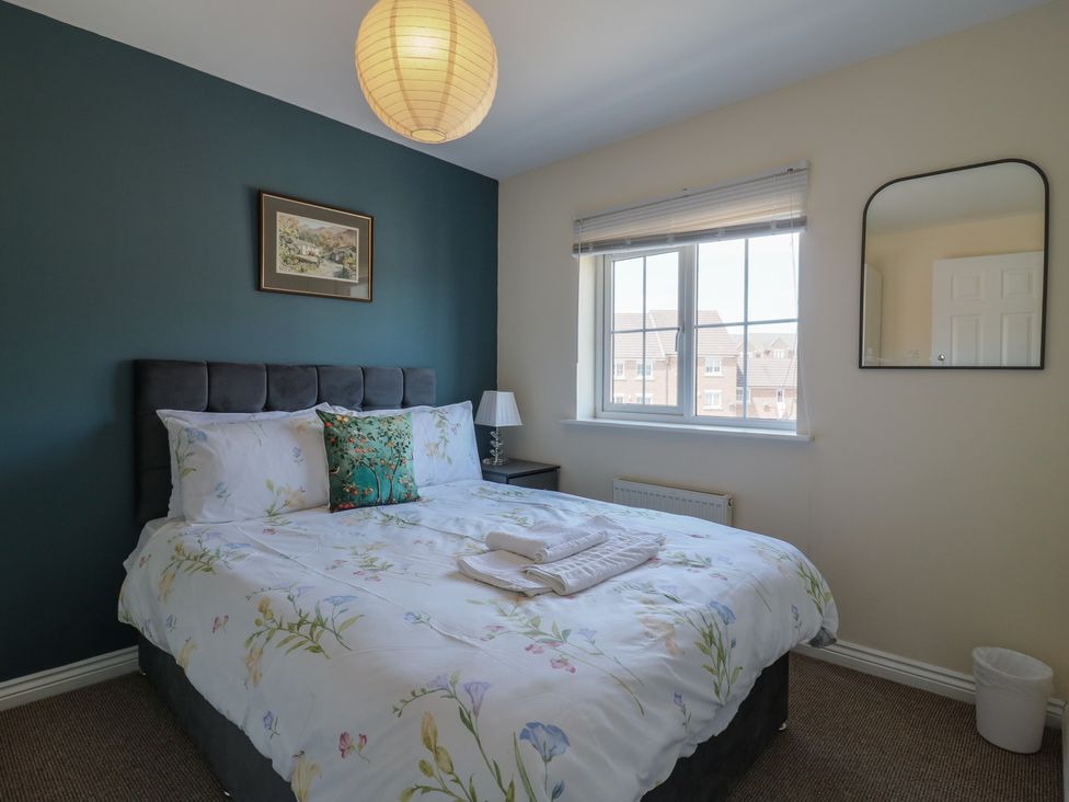 A bedroom with a bed and a bedside table at Gem Relax in Leighton Buzzard