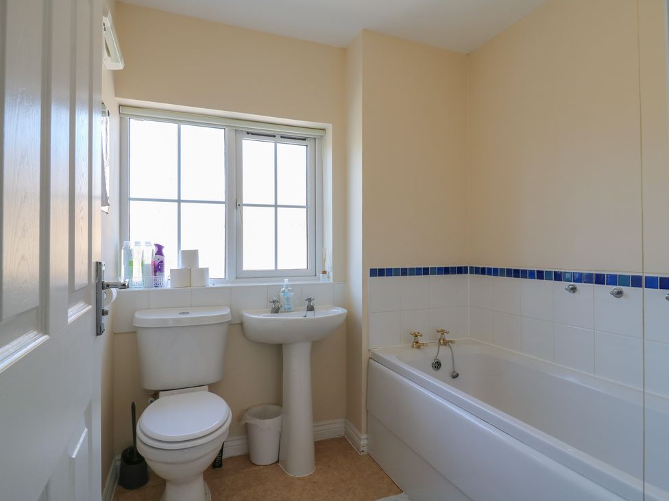 A bathroom with a bathtub, sink, and toilet at Gem Relax in Leighton Buzzard