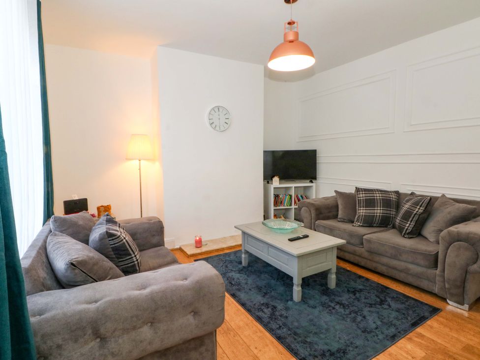 A living room with sofas and a television at Ash House 