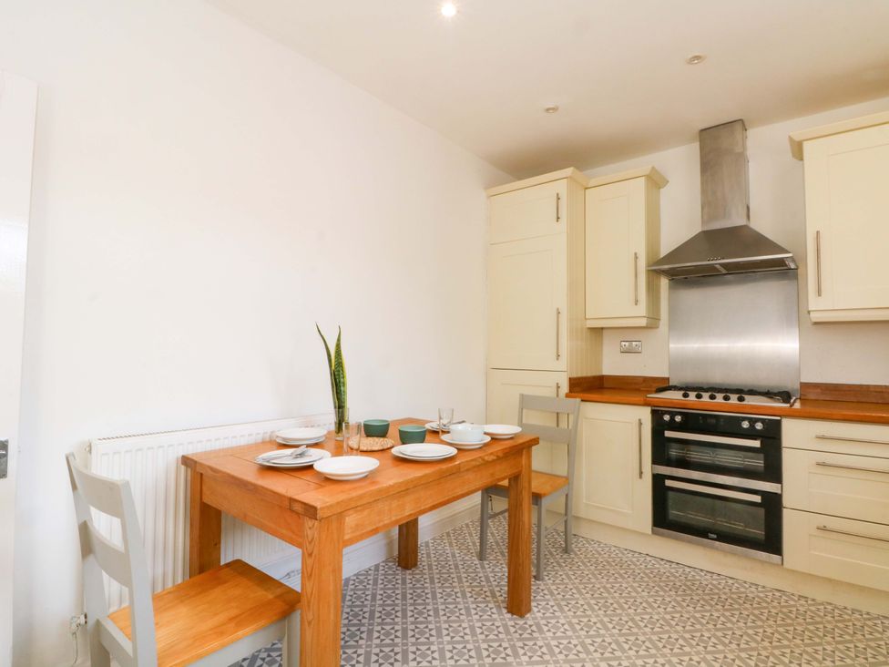 A kitchen with a wooden table and chairs at Ash House 