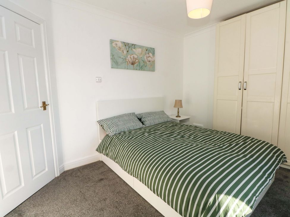 A bedroom with a bed and wardrobe at Ash House