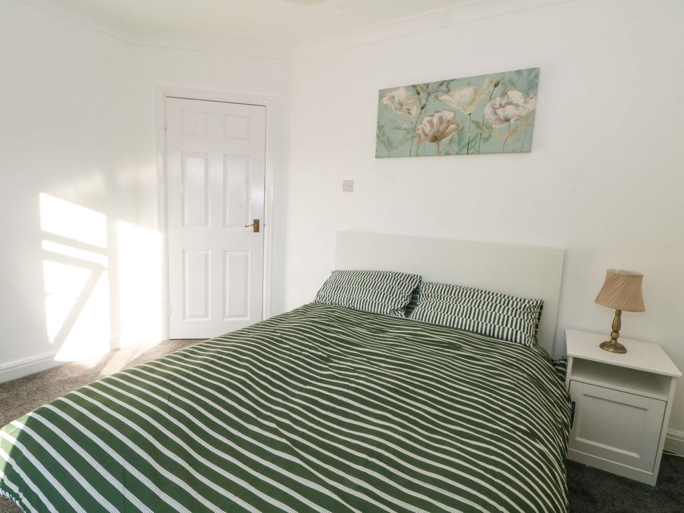 A bedroom with a bed, lamp, and wall art at Ash House in 
