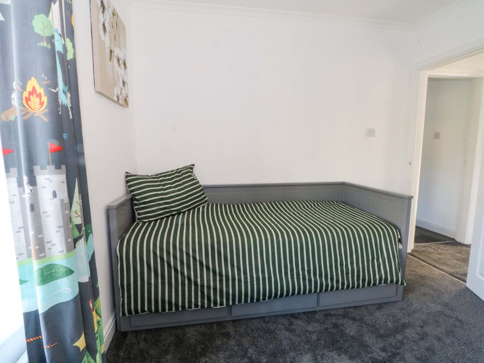 A bedroom with a daybed and curtains at Ash House