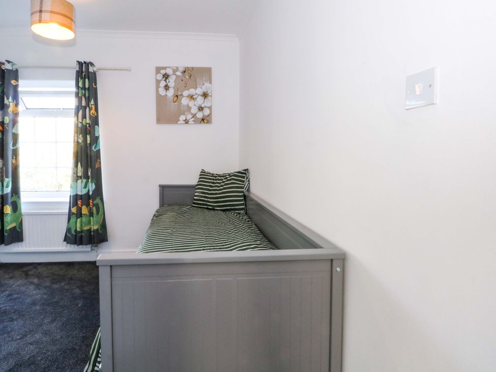 A bedroom with a bed and curtains at Ash House