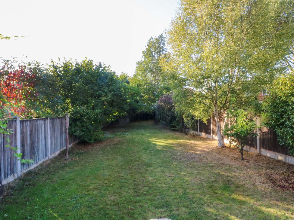 A garden with grass and trees at Ash House