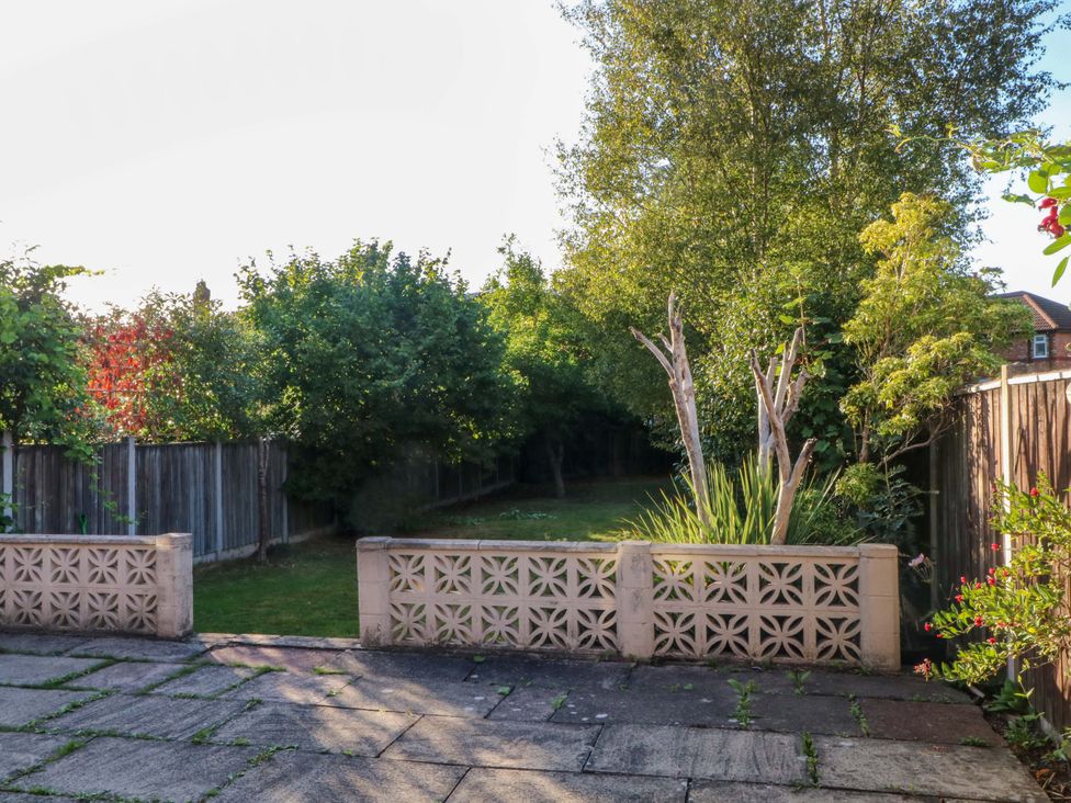 A garden with trees and a fenced area at Ash House