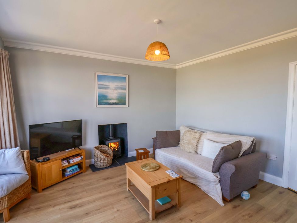 A living room with a sofa and television at Floraville