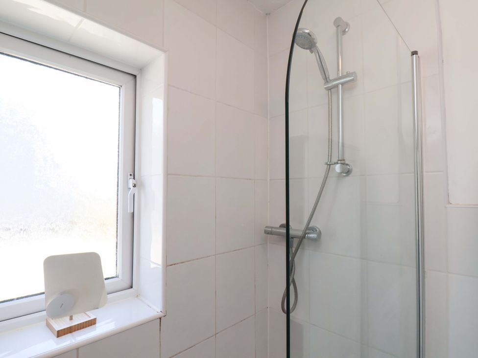 A shower area with a window and a wooden stand in Floraville