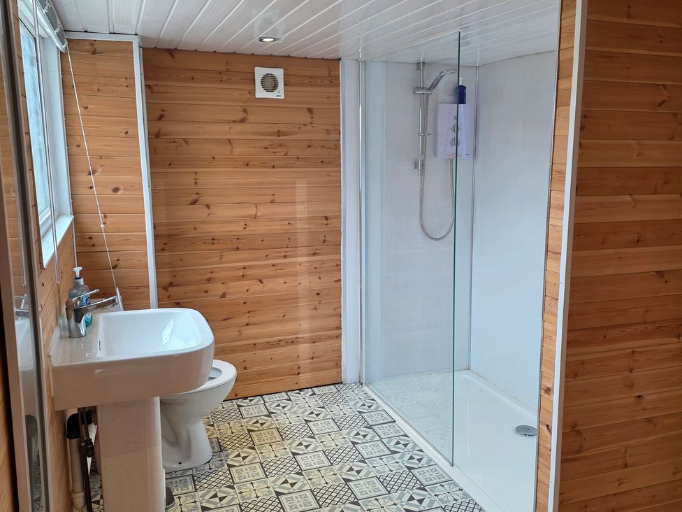 A bathroom with a shower, sink, and toilet at Floraville in Cayton Bay