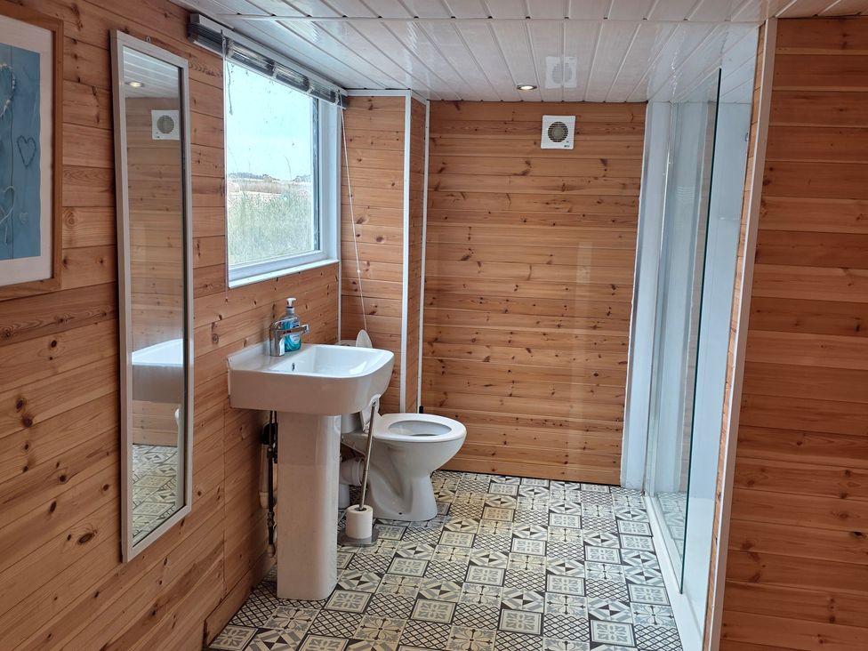A bathroom with a sink, toilet, and shower at Floraville in Cayton Bay