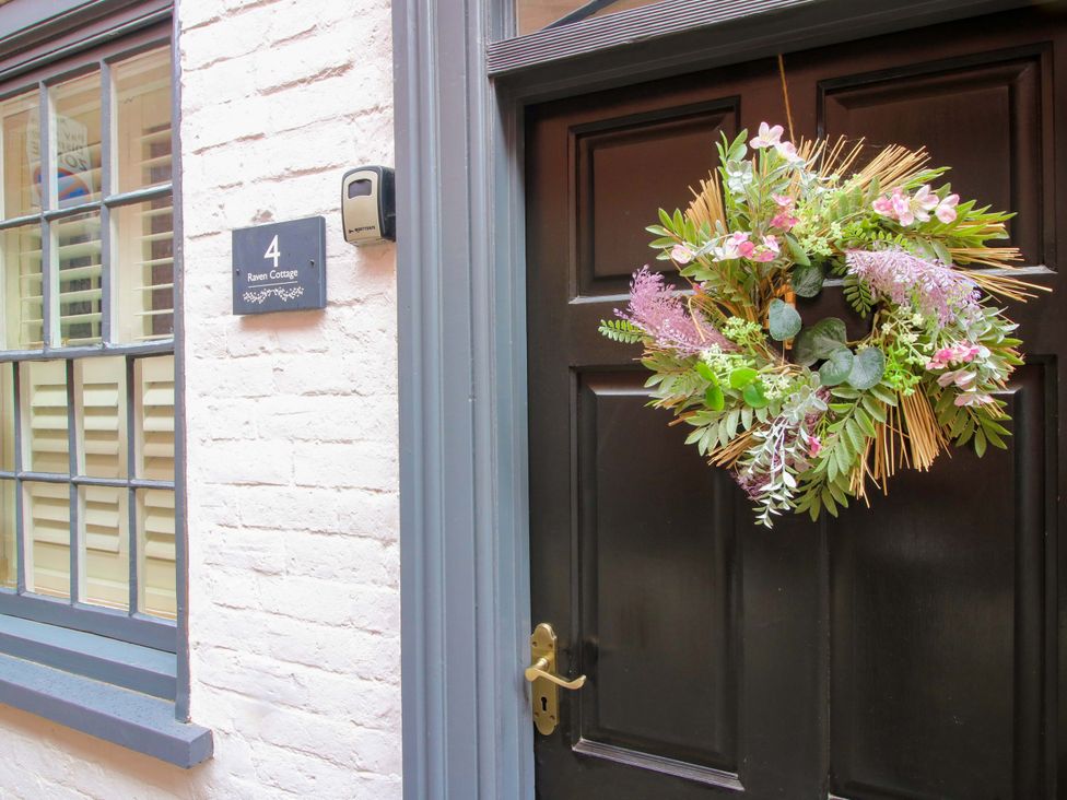An entrance with a door, a wreath, and a sign at Raven Lane Retreat in Ludlow
