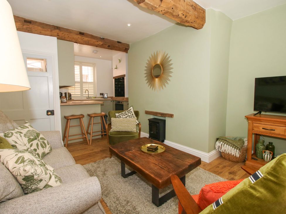 A living room with a sofa coffee table and television at Raven Lane Retreat in Ludlow