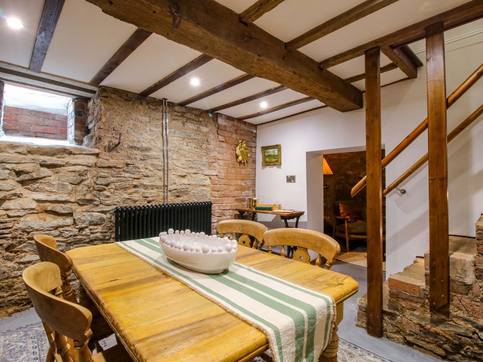 A dining room with a wooden table and chairs at Raven Lane Retreat in Ludlow