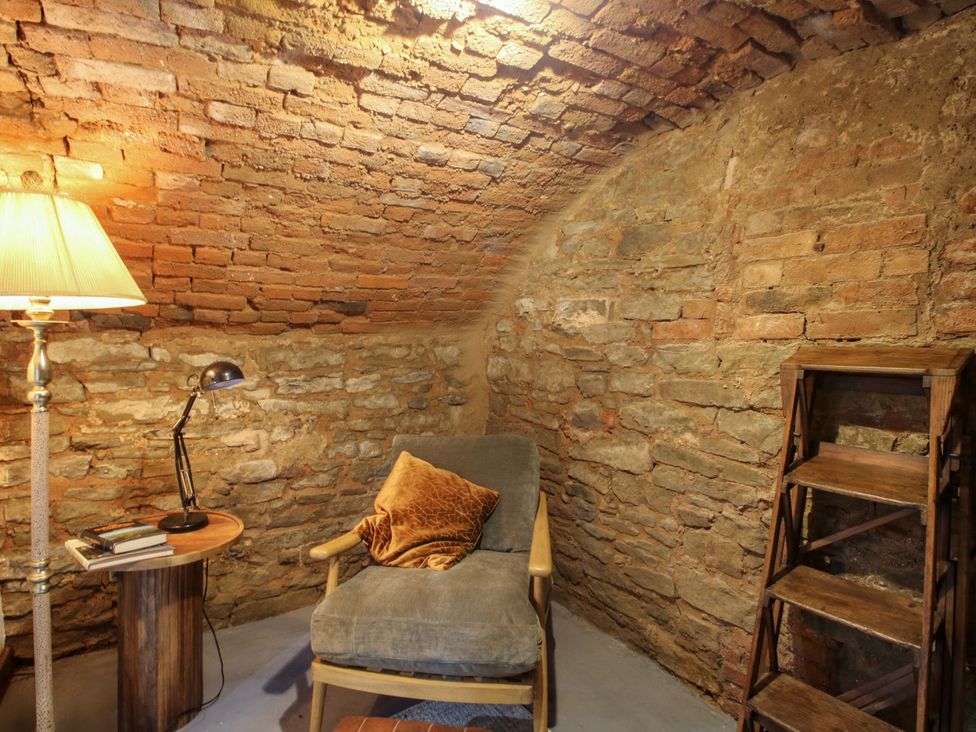 A sitting room with a chair and lamp at Raven Lane Retreat Ludlow