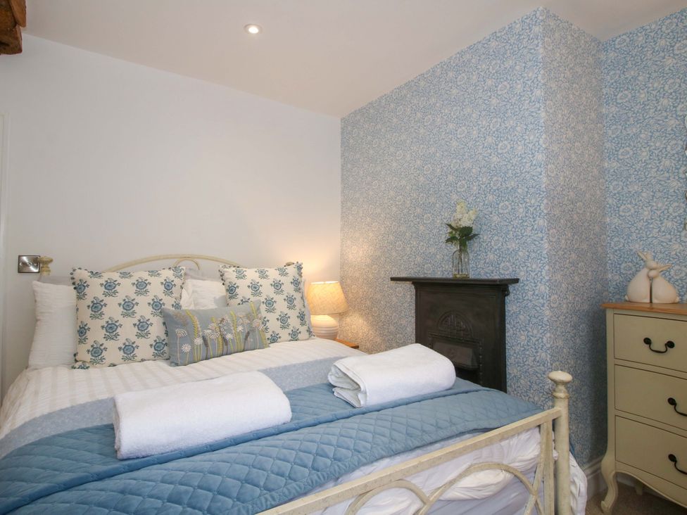 A bedroom with a bed and bedside lamp at Raven Lane Retreat Ludlow
