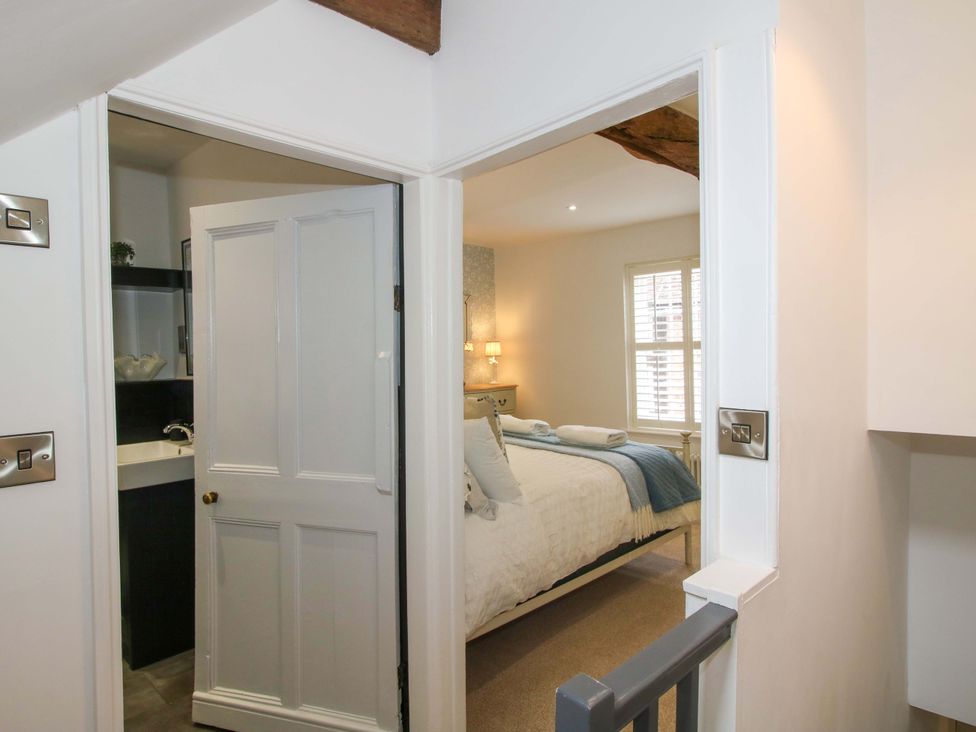 A bedroom with a bed and lamp visible at Raven Lane Retreat in Ludlow