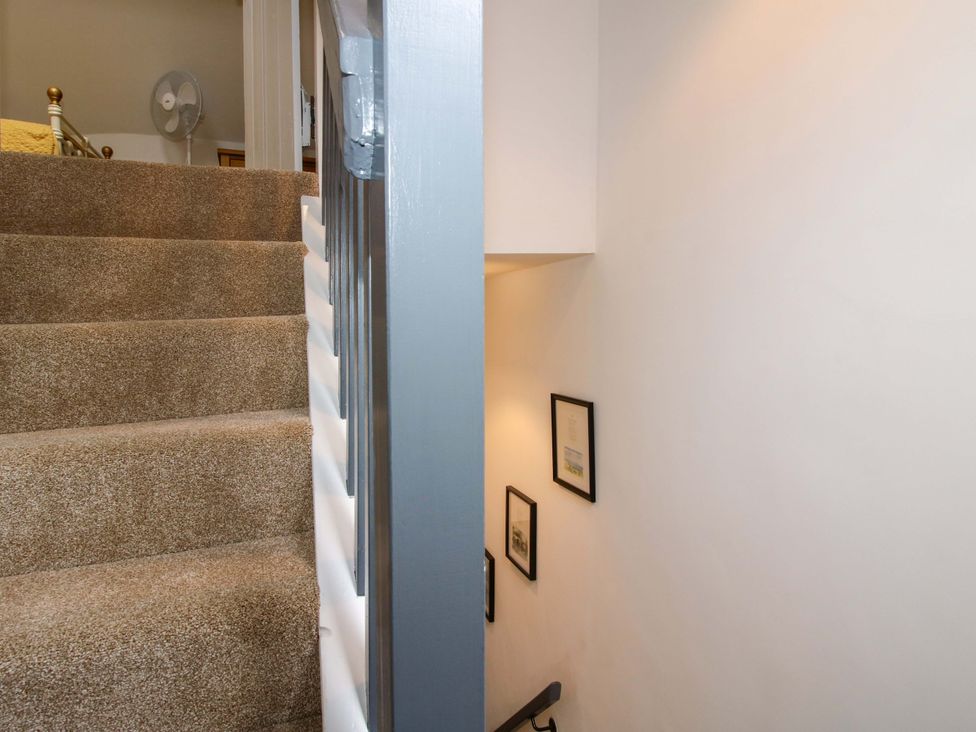 A staircase with frames on the wall at Raven Lane Retreat in Ludlow