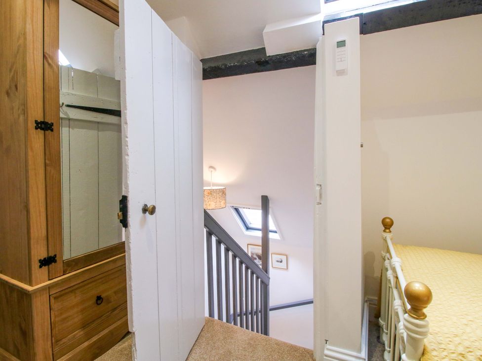 A bedroom with stairs leading down and an armoire at Raven Lane Retreat in Ludlow