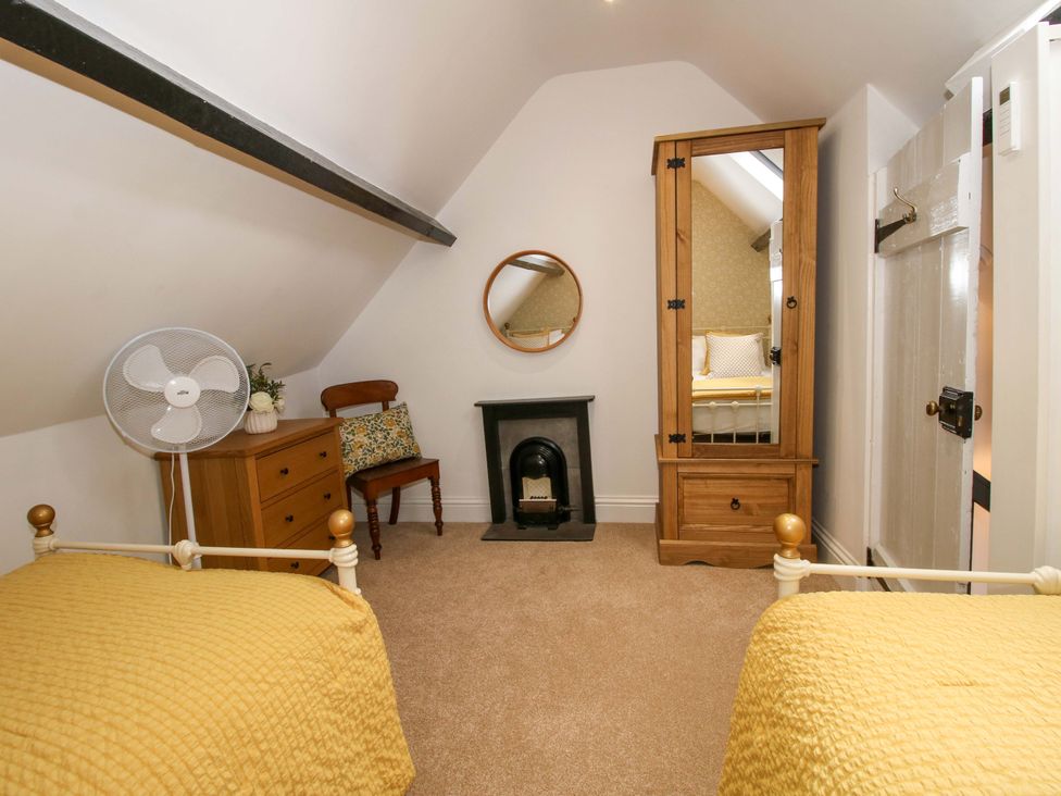 A bedroom with two beds and a wardrobe at Raven Lane Retreat in Ludlow