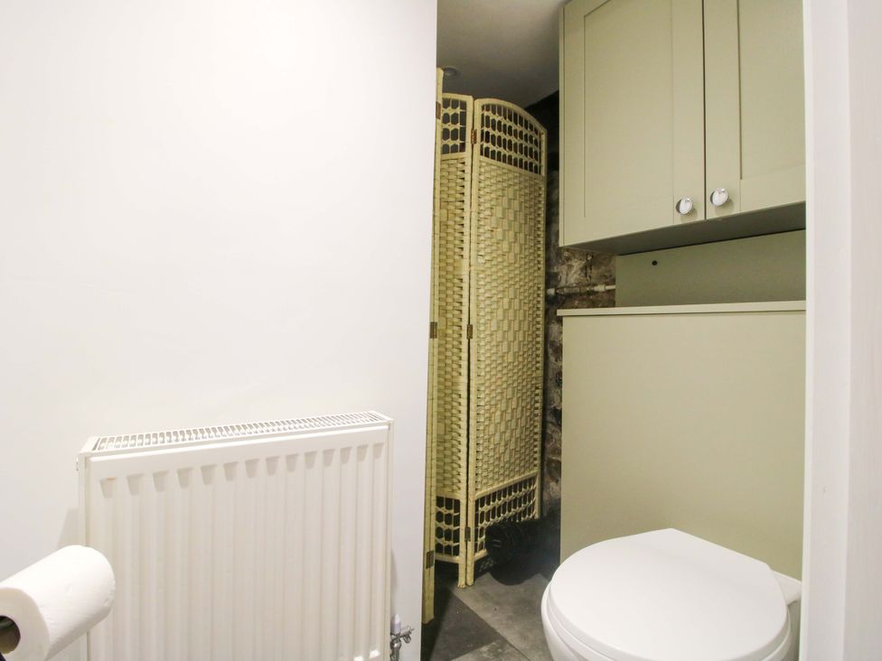 A bathroom with a toilet and a cabinet at Raven Lane Retreat in Ludlow