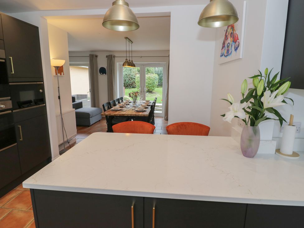 A kitchen with a dining area and a sofa at Harran in Pershore