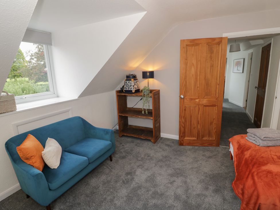 A bedroom with a sofa and shelf at Harran in Pershore