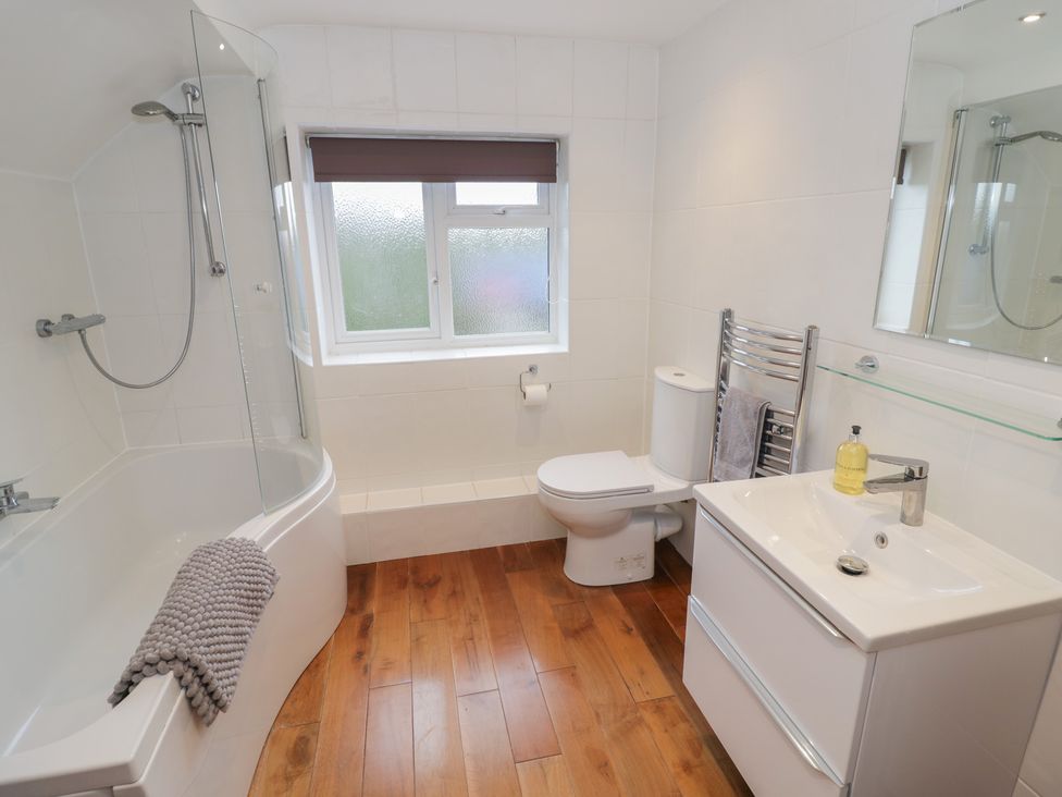 A bathroom with a bathtub, toilet, and sink at Harran in Pershore