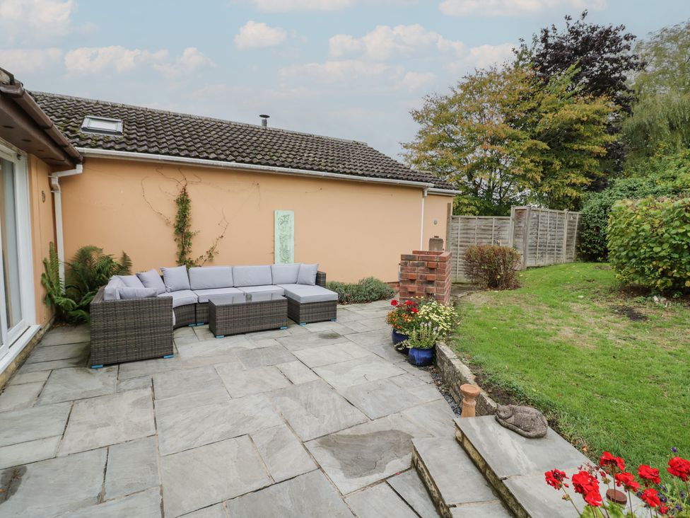 A garden with a sectional sofa and planters at Harran in Pershore