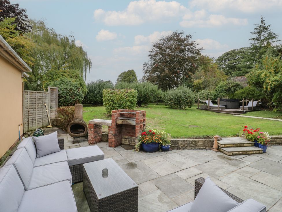 A garden with a sofa and barbecue area at Harran in Pershore
