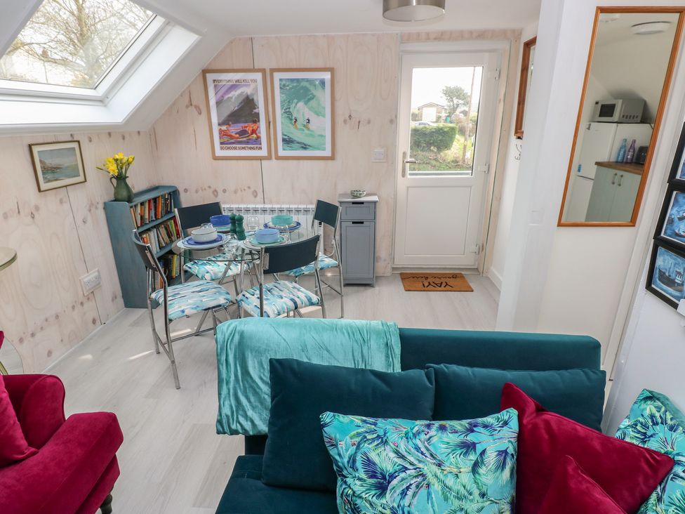 A living room with a dining area and a door leading outside at Over the way Cosheston near Pembroke