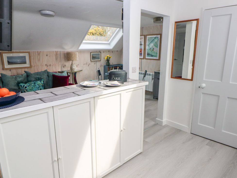 A kitchen with a counter and chairs at Over the way Cosheston near Pembroke