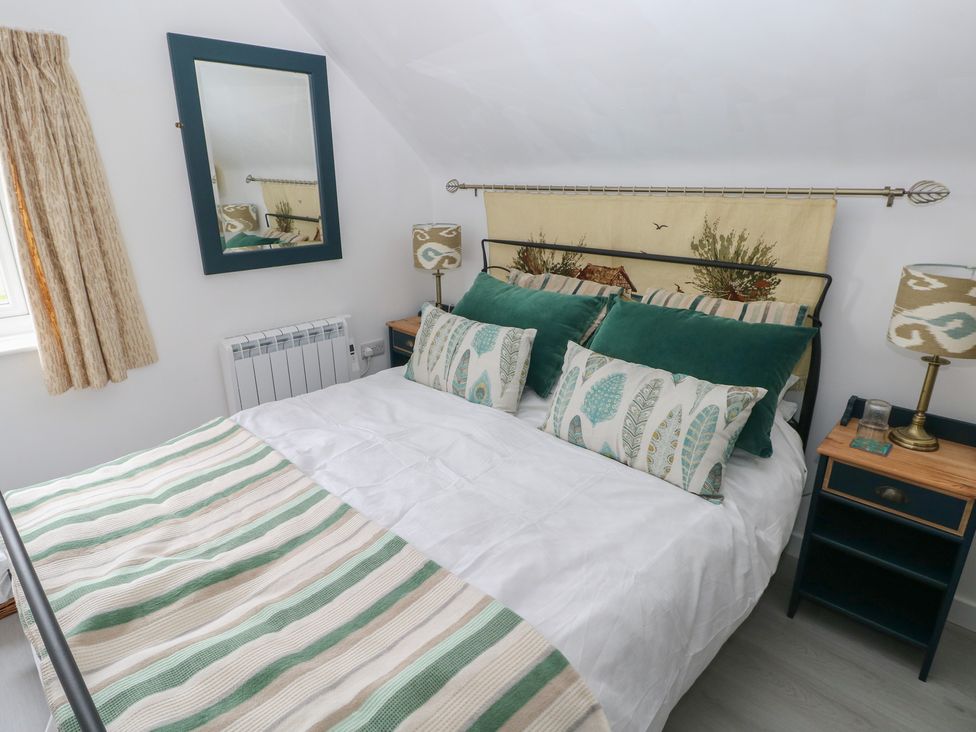 A bedroom with a bed and side table at Over the way Cosheston near Pembroke