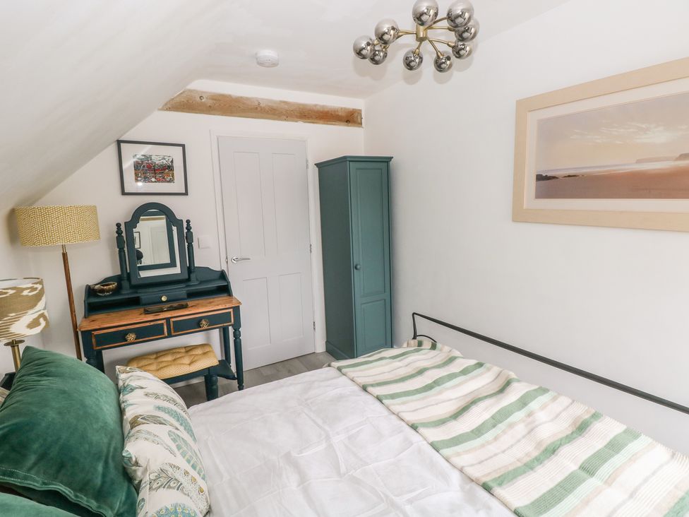 A bedroom with a bed and wardrobe at Over the way Cosheston near Pembroke