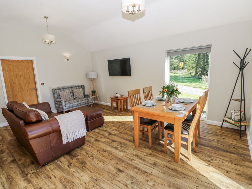 A living room with a sofa and dining area at Dwrgi in Llanybydder