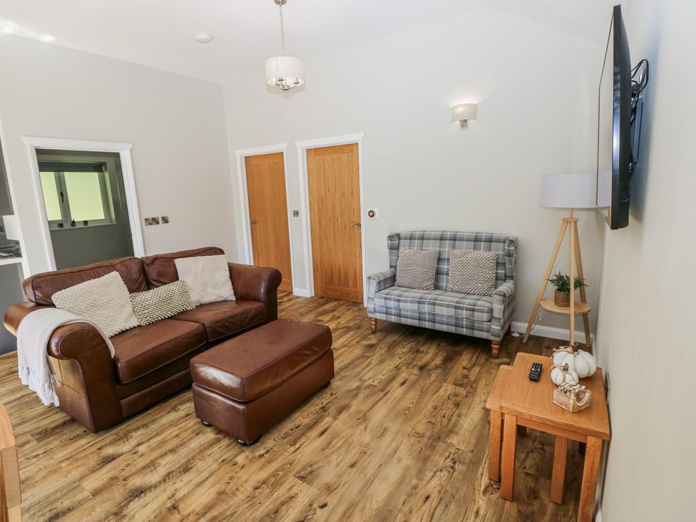 A living room with a sofa and ottoman at Dwrgi in Llanybydder