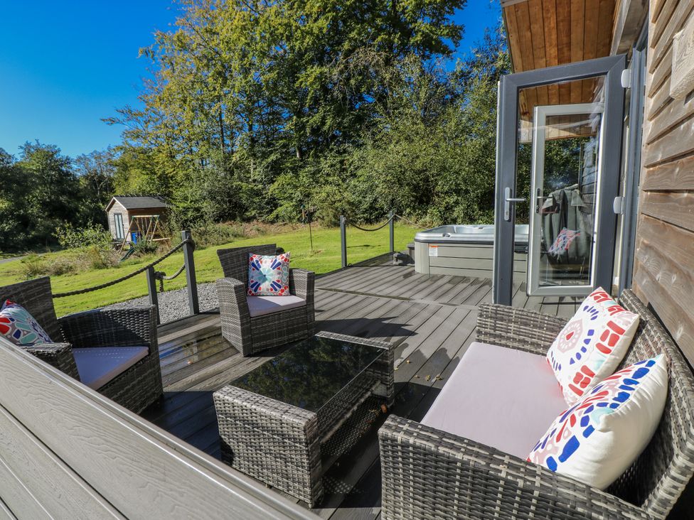 An outdoor seating area with a hot tub at Dwrgi in Llanybydder