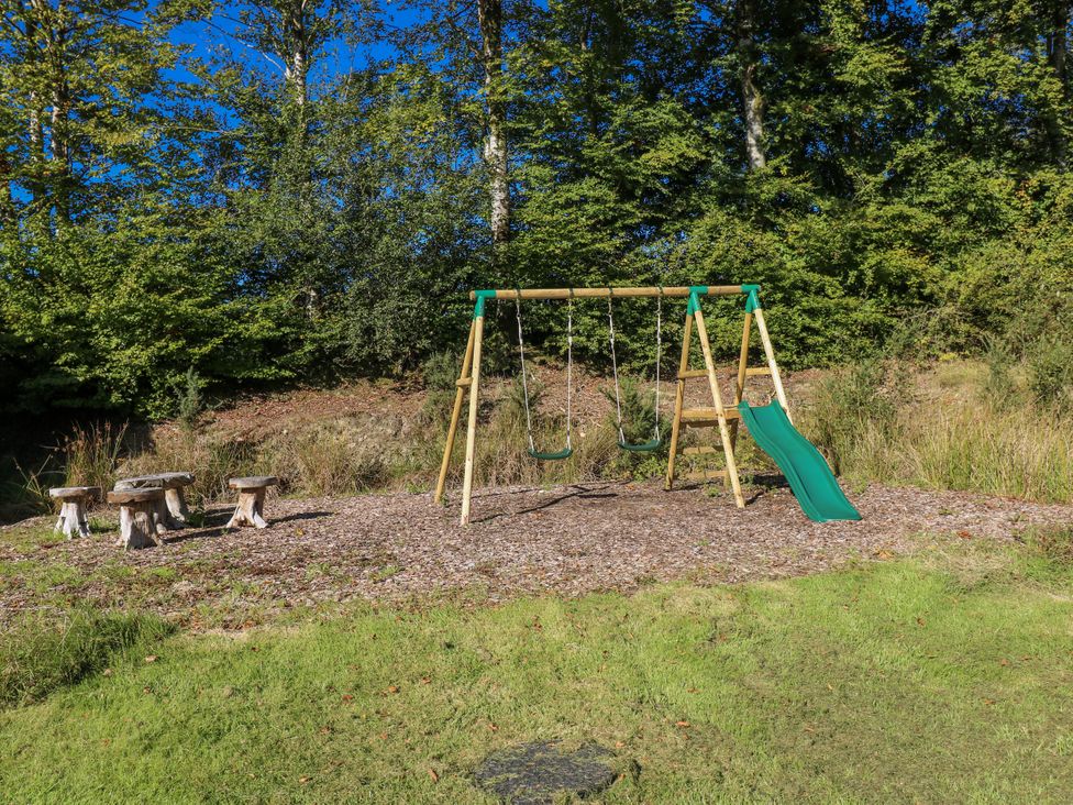 A playground with swings and a slide at Dwrgi in Llanybydder