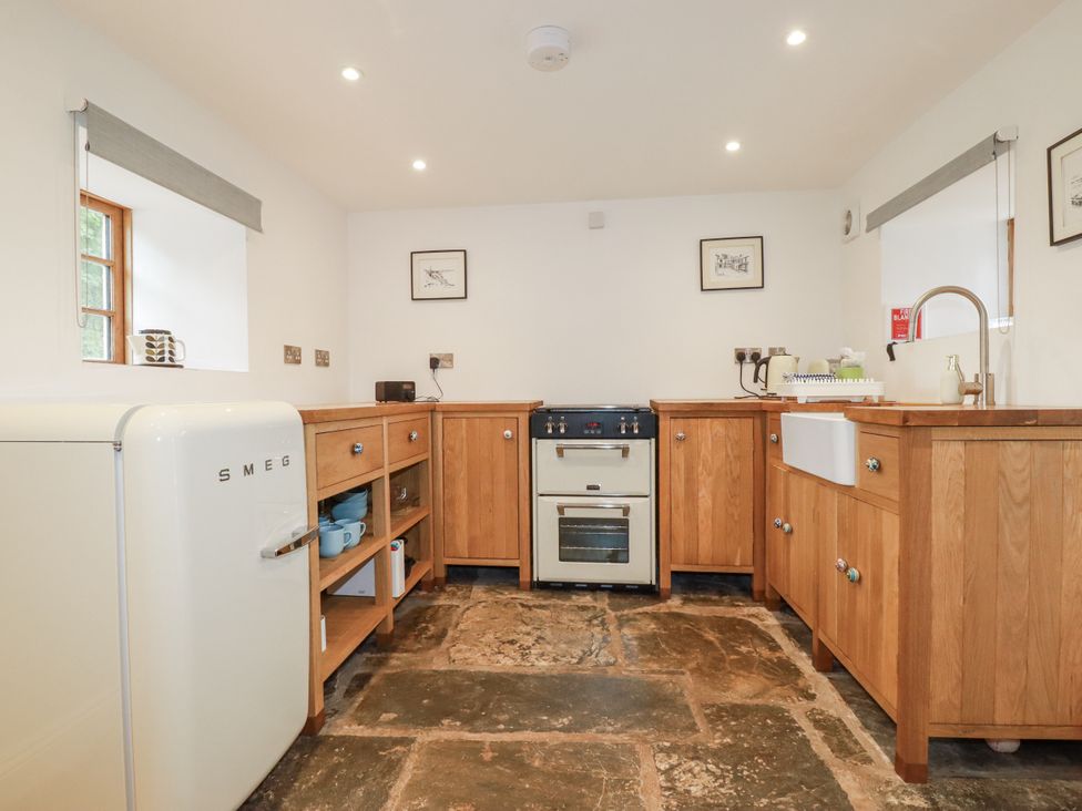 A kitchen with wooden cabinets and appliances at The Old Dairy 