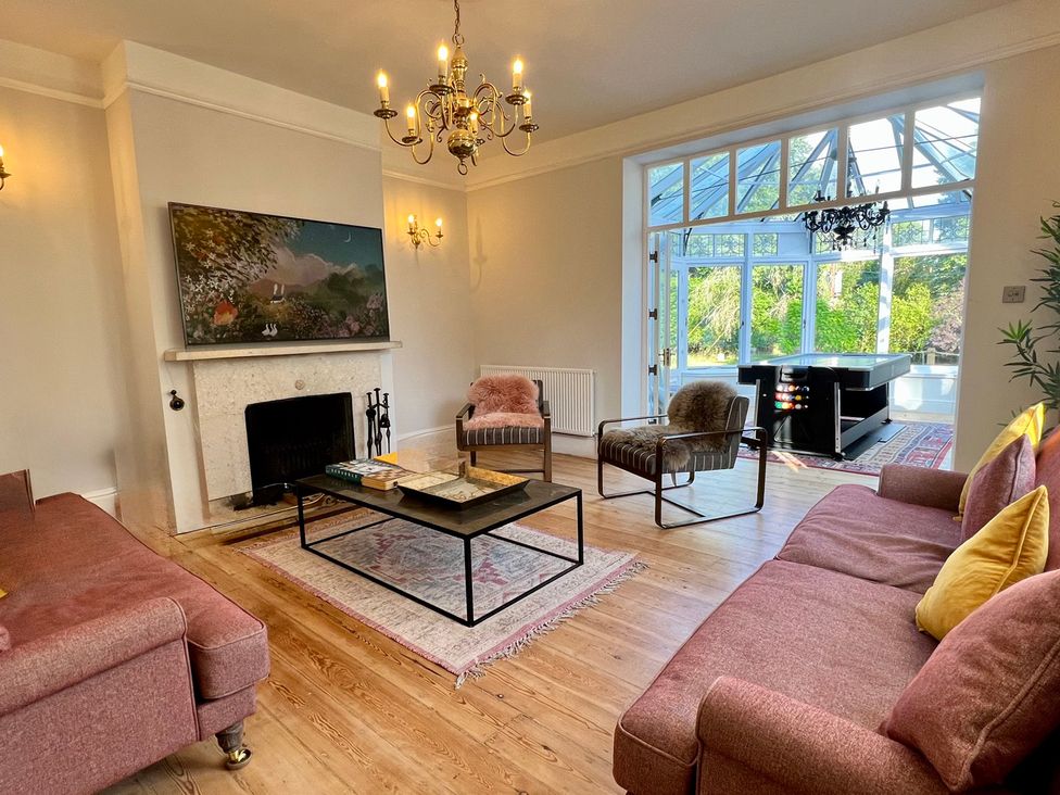 A living room with a coffee table and television at Your Country House in Reading