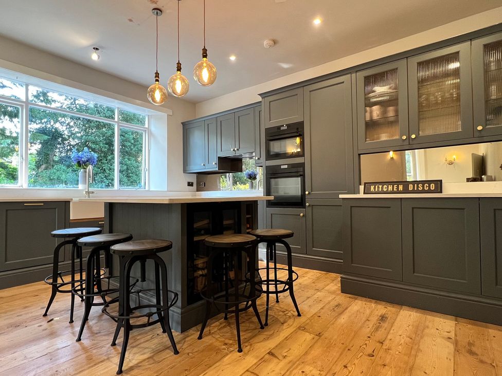 A kitchen with an island and stools at Your Country House in Reading