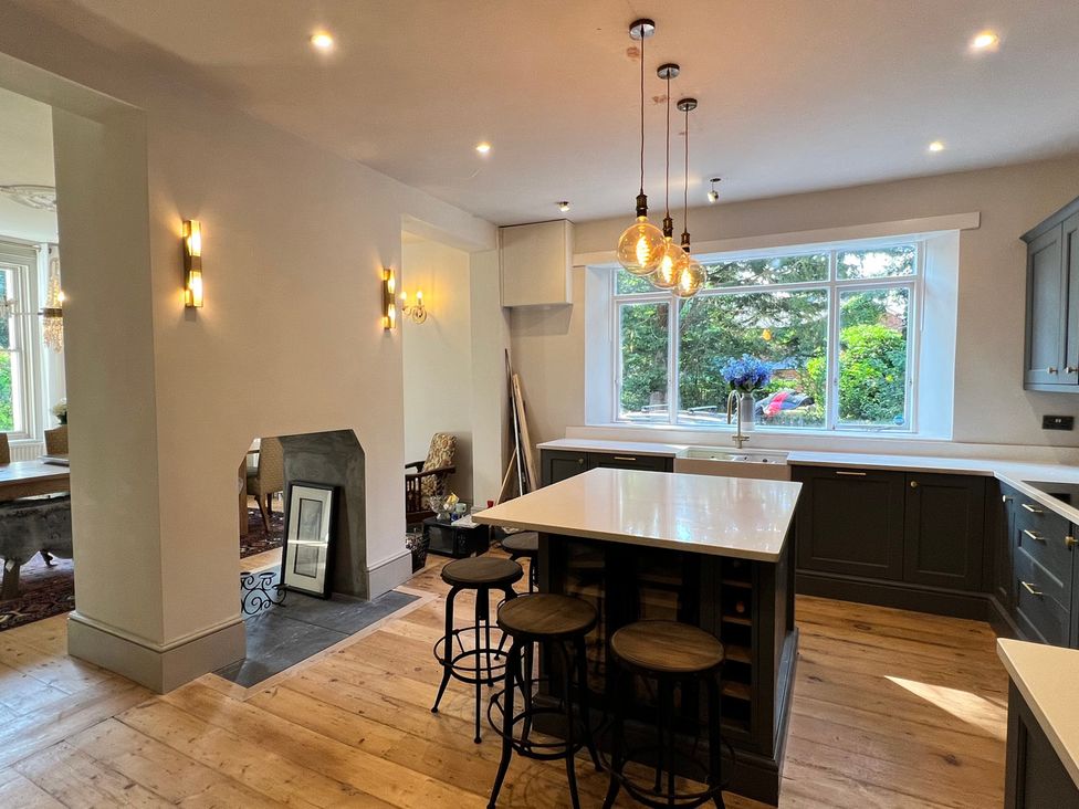 A kitchen with an island and bar stools at Your Country House in Reading