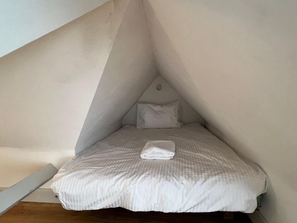 A bed with a pillow and blanket in an attic room at Your Country House Reading